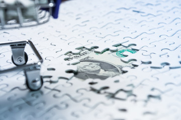 Shopping cart full of jigsaw puzzle on money dollar background, Business solution concept ,key for...