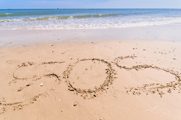 Write a symbol for help on the sand. SOS symbol on the sand.