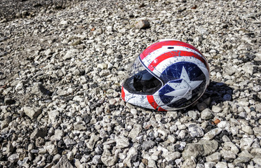 battered motorcycle helmet on the beach