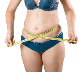 Fat girl with excess weight measures her belly and waist with a measuring tape. Woman in lingerie on white isolated background