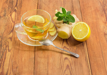 Tea with mint, ginger and lemon slices in glass cup