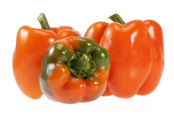 Vegetables of orange and green pepper isolated on white background.