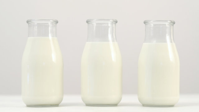 Three milk or yogurt bottles on white background. Selection of quality dairy products. Wide choice in shops. Copyspace concept