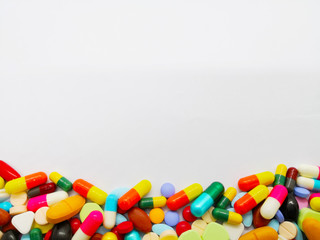 Many colorful medicine tablets and pills isolated on white background. Copy space.