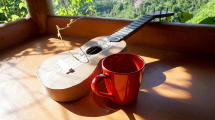 Ukulele and red coffee cup