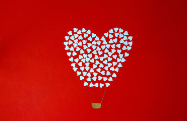 white heart from a paper on a red background