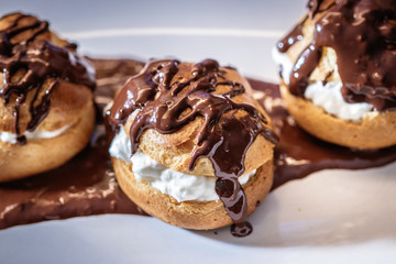Profiteroles (choux à la crème) - French choux pastry balls filled with cottage cheese and topped with hot, melted chocolate sauce