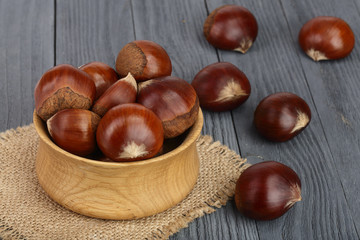 chestnut in wooden bowl on black wooden background