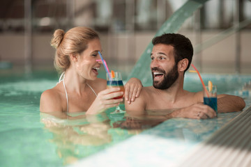 Cheerful happy couple relaxing in swimming pool