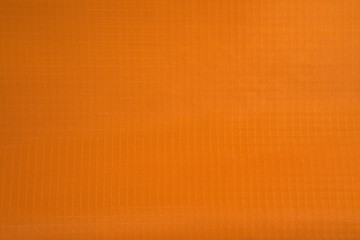 Synthetic fabric texture. Background of orange textile