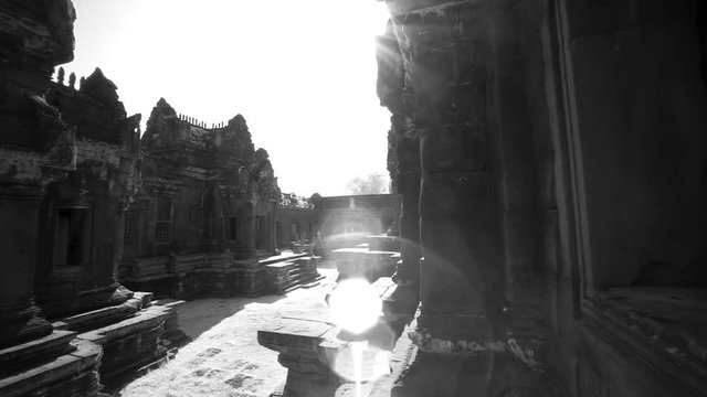 Whip pan transition movement across the interior of Banteay Srei temple with lens flares.