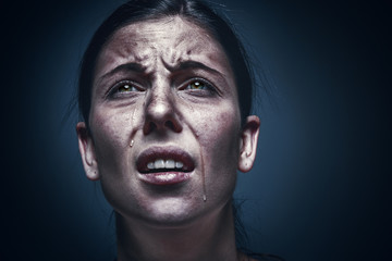 Close up portrait of a crying woman with bruised skin and black eyes
