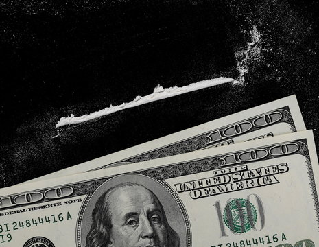 Cocaine lines and hundred dollar bills isolated on black background, top view