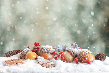 Fototapeta na wymiar Christmas decoration in snowy winter bokeh background. Pine cones, acorns and Oak leaves.