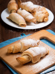 Delicious croissants on a bamboo board.