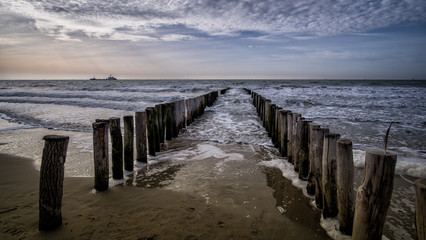 View on the wooden pier during sunny weather with clouds at the beach in Vlissingen, Zeeland, Holland, Netherlands