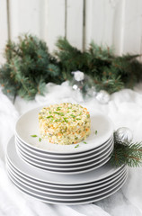 Traditional celebratory salad Olivier on a white plate with a New Year's or Christmas decor. Soviet traditions.