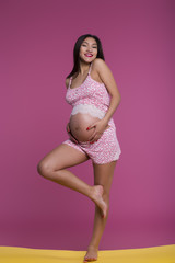 Cute pregnant girl in pink pajamas