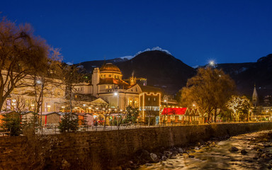 Meran Merano in South Tyrol, Italy, during the Christmas with christmans market by night . Beautiful light and great atmosphere - obrazy, fototapety, plakaty