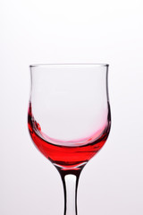Glasses with waves plash of red wine on a white background