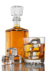 Glass of whiskey with ice and decanter on white background