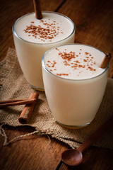 Eggnog houmemade with cinnamon and kakao for Christmas and winter holidays or wooden broun backgrounds