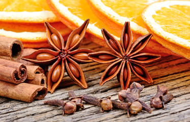 Anise star with clove cinnamon sticks and slice of dried orange on table