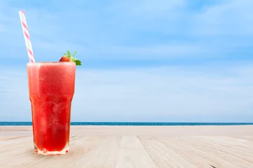 Crédence de cuisine en verre imprimé Jus Smoothie au jus de fraise en verre avec des fraises fraîches sur une table en bois avec fond de nature vue paysage de plage