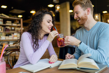 Young students spending time in coffee shop reading books