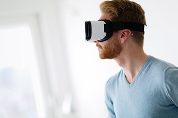 Man wearing virtual reality headset at home