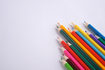Colored crayons background. Many different colored pencils on white background