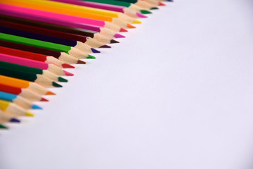 Colored crayons background. Many different colored pencils on white background