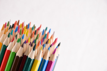 Colored crayons background. Many different colored pencils on white background