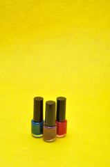 Bottles of colorful nail polish displayed against a yellow background