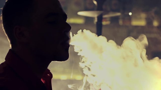Young man smoking hookah in a bar