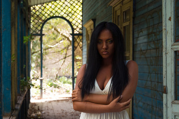 Portrait of young black woman against background of an old abandoned house 