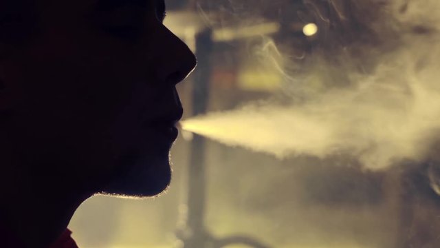 Young man smoking hookah in a bar