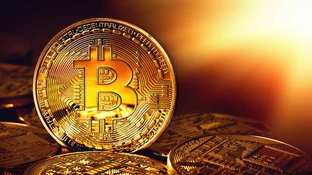 Golden Bitcoins on a gold background .Photo (new virtual money ) New crypto currency in the form of the coins. 