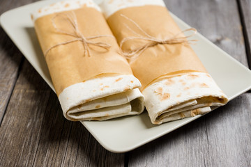 Shawarma with sauce on the rustic wooden background. Selective focus. Shallow depth of field.