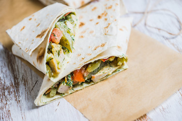 Shawarma with sauce on the rustic wooden background. Selective focus. Shallow depth of field.