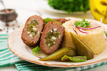 Zrazy cutlets with minced meat with pickled cucumber and eggs and garnish of bulgur