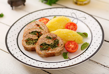 Roll of turkey minced meat with spinach and red sweet pepper with garnish of mashed potatoes