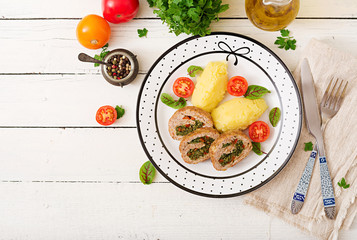Roll of turkey minced meat with spinach and red sweet pepper with garnish of mashed potatoes