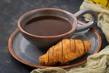 Cup of fragrant coffee and a croissant. Morning breakfast