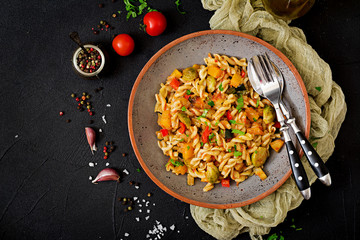Vegan Fusilli vegetable paste with pumpkin, Brussels sprouts, paprika and carrot on a dark...