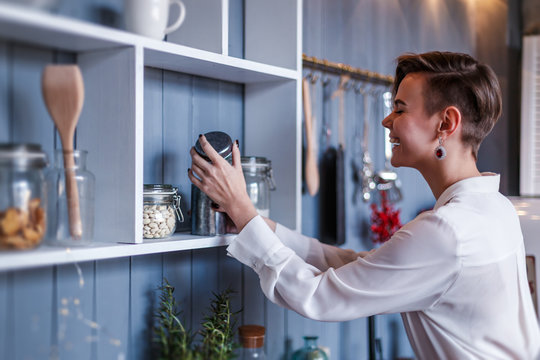 Cute and stylish woman is posing on a modern kitchen 