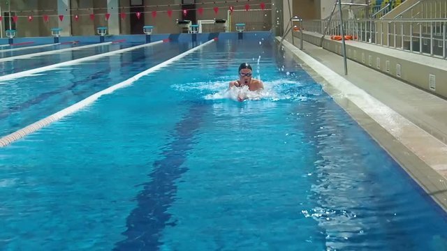 Athlete in the pool. The athlete swims a breaststroke.