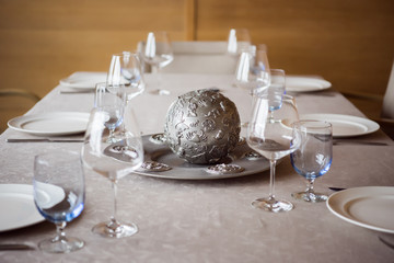 close up view of arrangement of cutlery, decorations and empty wineglasses on table in restaurant