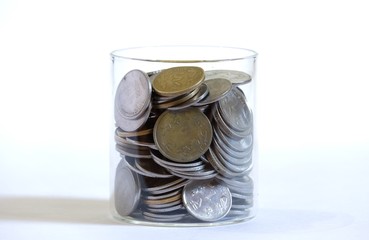 stacked indian rupee coins in a glass jar