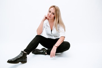 Fototapeta premium Young blonde girl sitting in Studio on white background